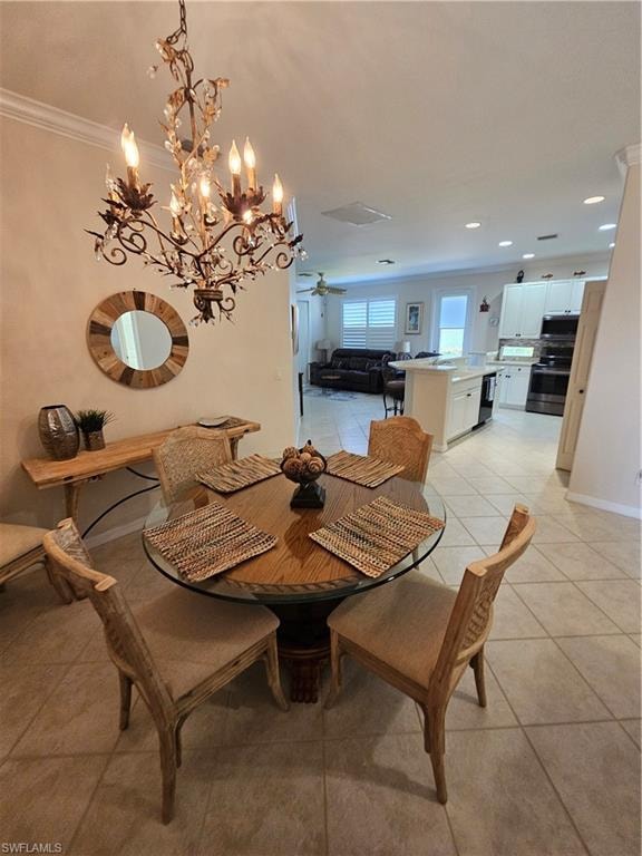 Dining area featuring light tile patterned floors, a ceiling fan, suspended lighting, and ornamental molding