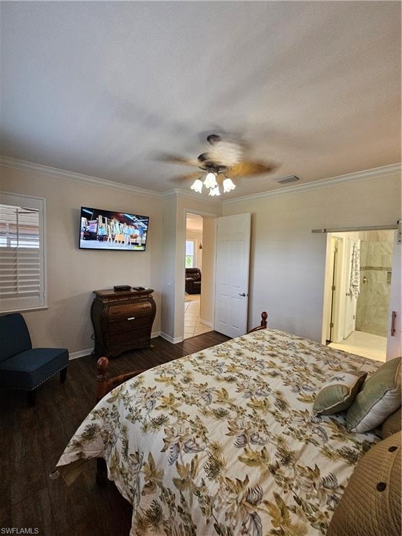 Bedroom featuring dark wood-style floors, crown molding, ceiling fan, and ensuite bath