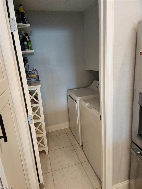 Dedicated laundry area featuring tile flooring and a built-in shelf
