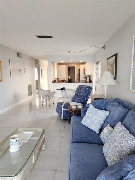 Open-concept living area with light-toned tile flooring throughout