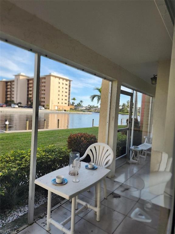 Screened patio with tiled flooring and a serene canal view