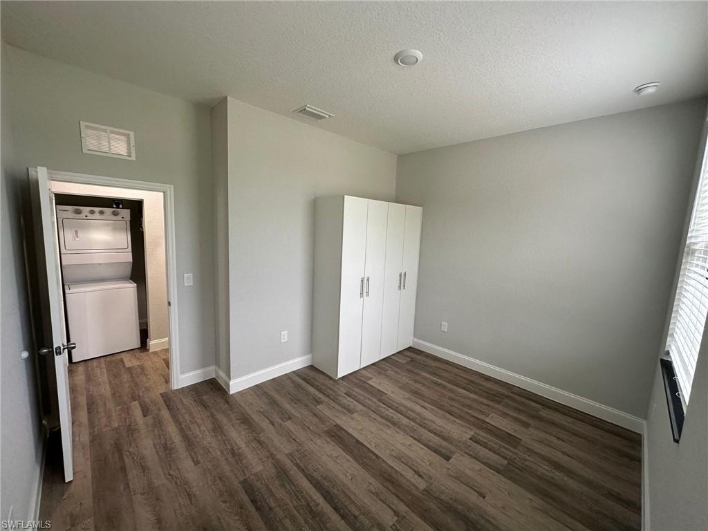 Room featuring wood-finish flooring, light gray wall paint, and white baseboards