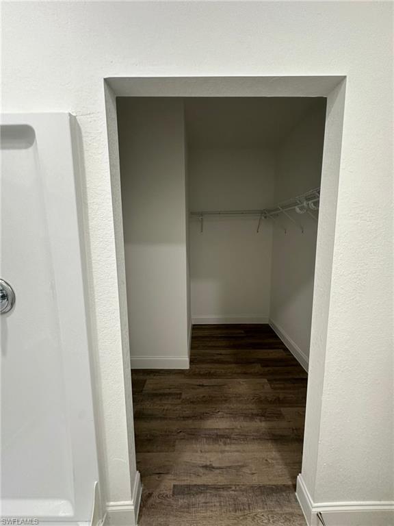 Walk-in closet featuring wood-finish flooring, white baseboards, and a wire shelving system