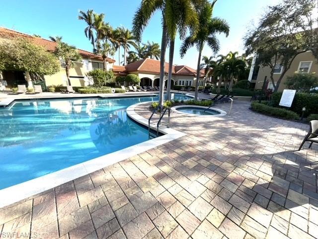 View of pool featuring a community hot tub and a patio area