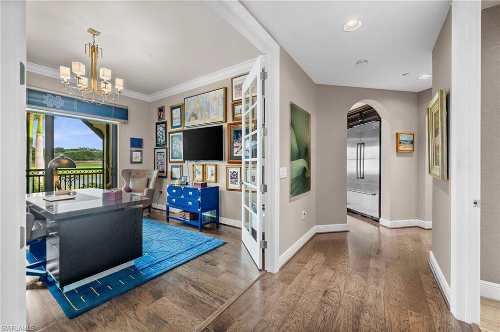 Office area featuring arched walkways, wood finished floors, a chandelier, and recessed lighting