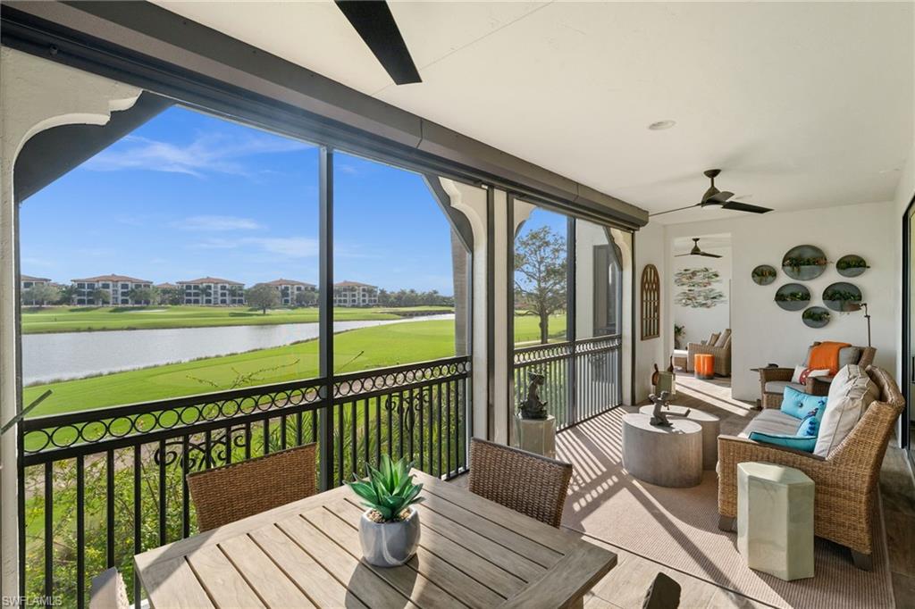Sunroom featuring a water view, a ceiling fan, and golf course view