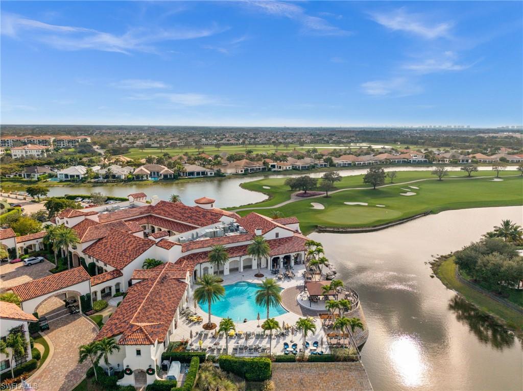Aerial view of residential area featuring a nearby body of water and a golf club