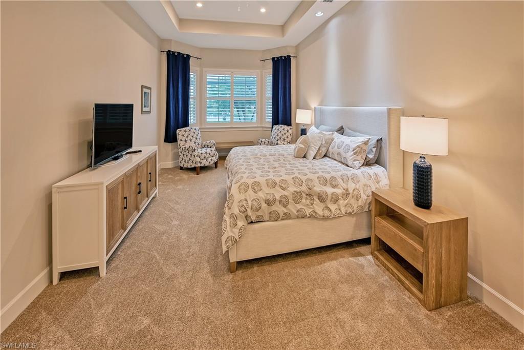 Carpeted bedroom featuring a raised ceiling