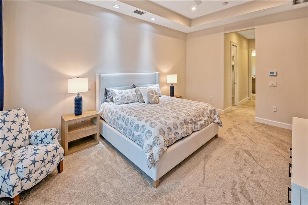 Bedroom featuring carpet flooring, ceiling fan, and a tray ceiling