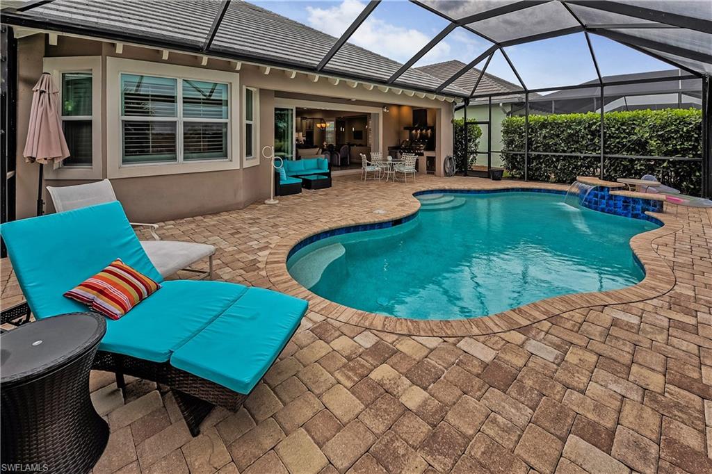 View of swimming pool featuring outdoor lounge area, pool water feature, a lanai, and a patio area