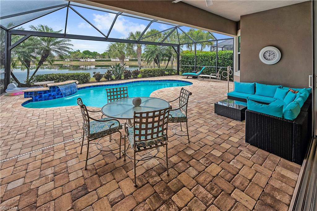 View of swimming pool featuring an outdoor living space, a water view, pool water feature, and a patio area