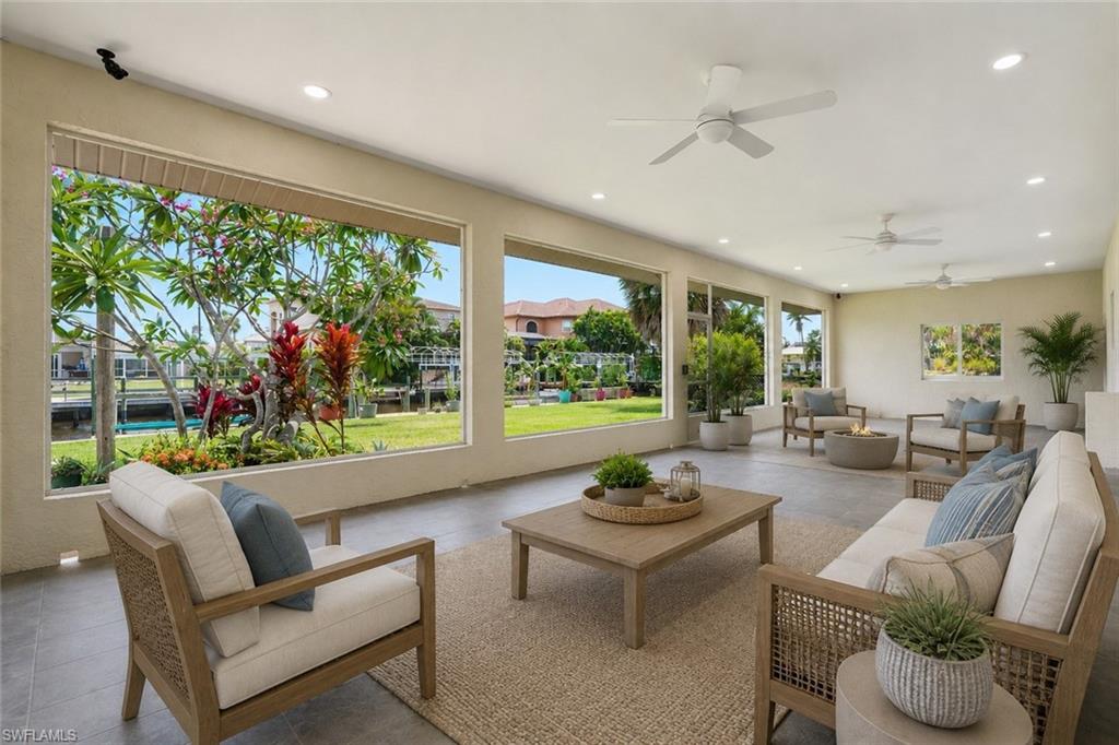 Expansive covered patio featuring large windows, recessed lighting, and multiple ceiling fans