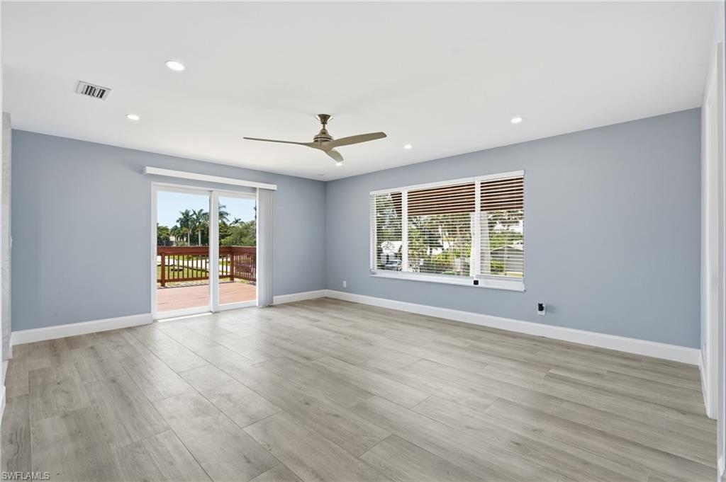 Spacious room featuring light wood-finish flooring, recessed lighting, and a ceiling fan