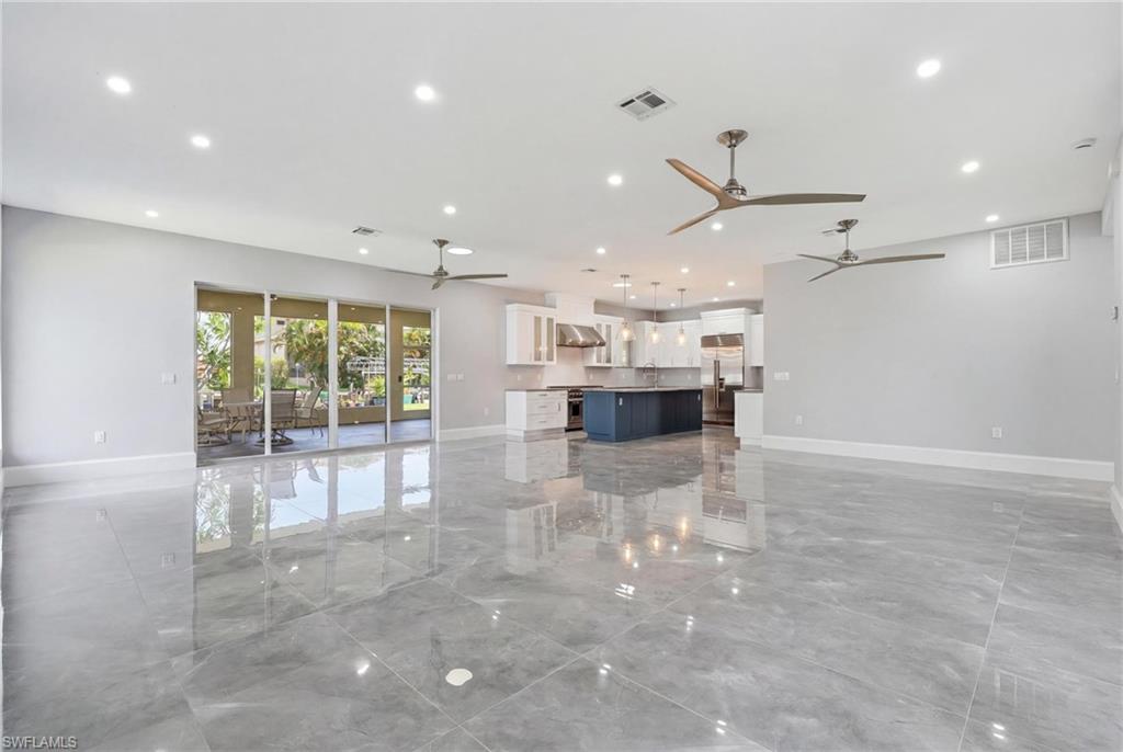Spacious open-concept living area featuring large format tile flooring and recessed lighting