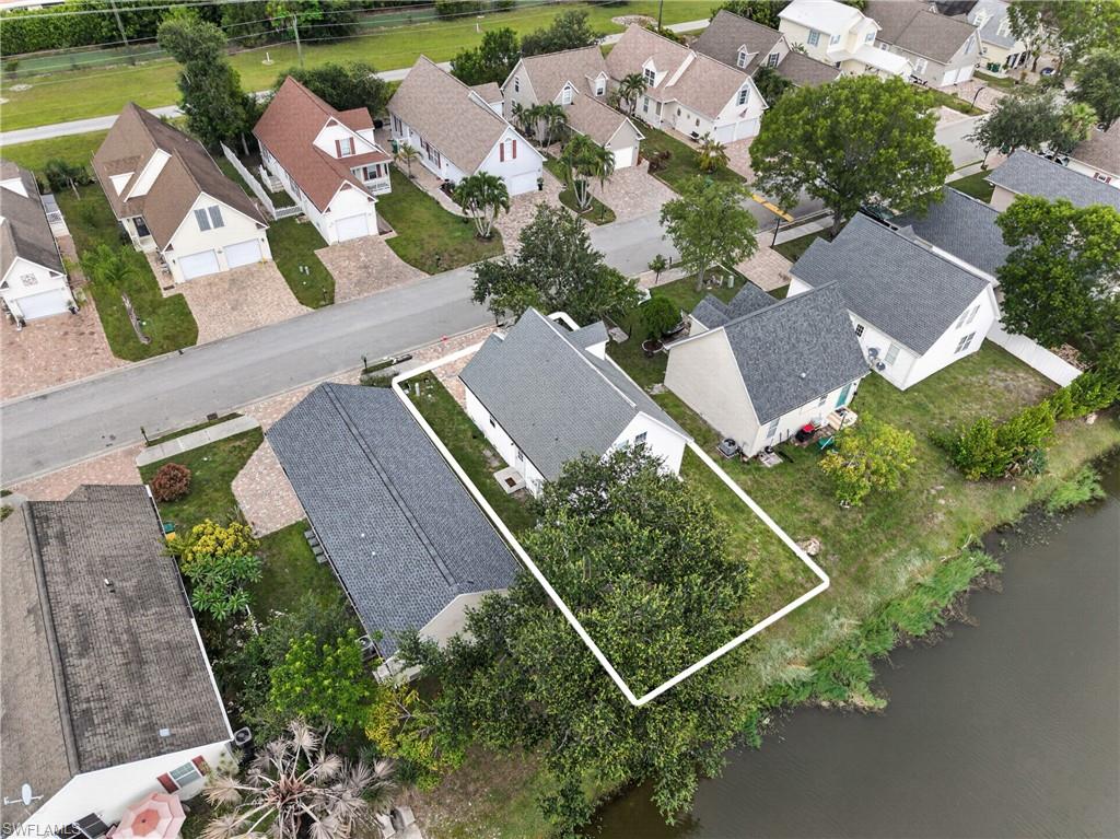 Waterfront property featuring a landscaped yard and mature trees