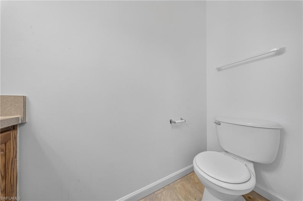 White toilet with coordinating toilet paper holder and towel bar