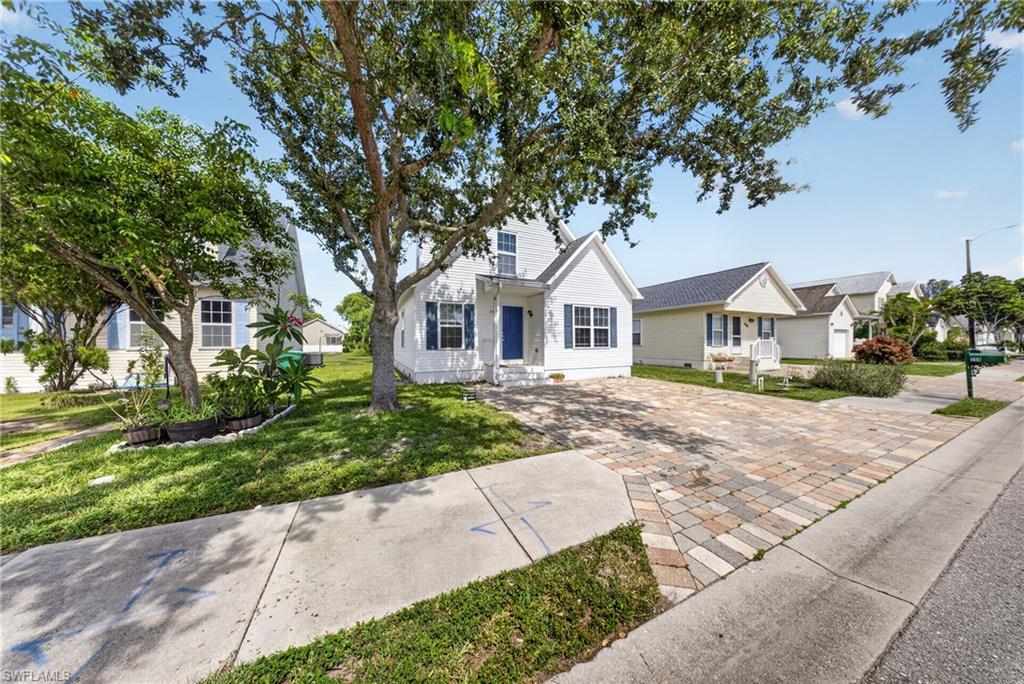 White residence featuring a blue front door, gable rooflines, and decorative window shutters