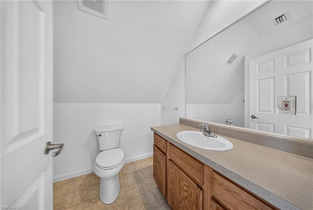 Bathroom featuring an integrated vanity sink with chrome hardware, wood-finish cabinetry, and a full-width mirror