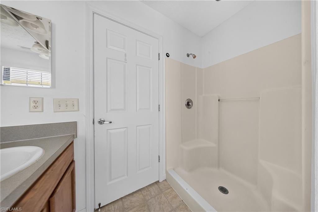 Bathroom featuring a vanity with a light-colored countertop, an integrated sink, and wood-finish cabinetry