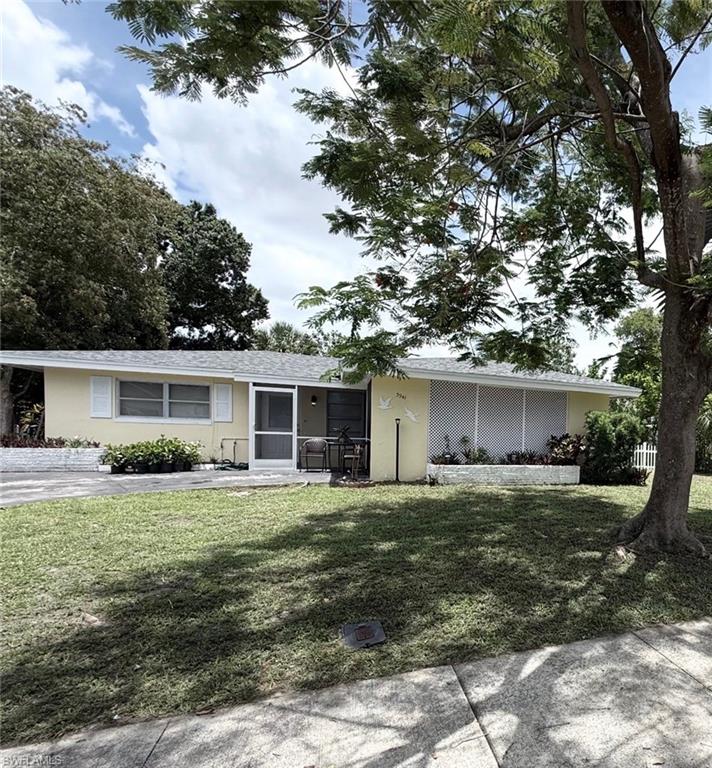 Ranch-style residence featuring a pale yellow exterior, white shutters, and a screened front entry