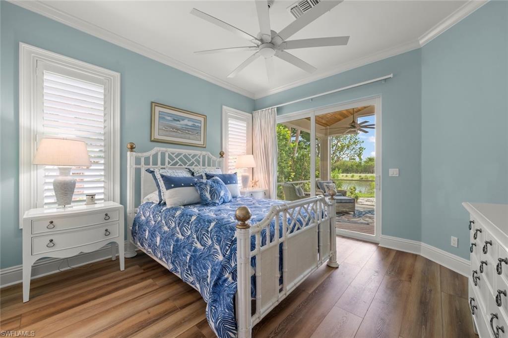 Spacious room featuring wood-finish flooring, crown molding, and a ceiling fan