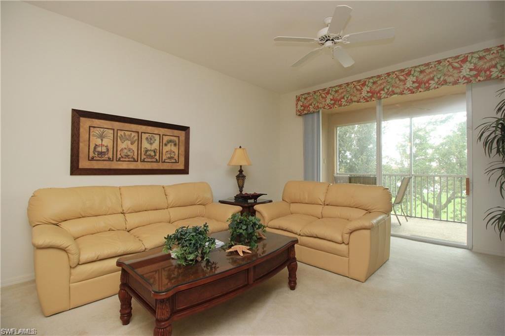 Living room with ceiling fan and light colored carpet
