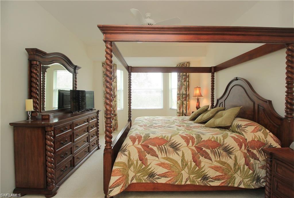 Bedroom with multiple windows, ceiling fan, and carpet