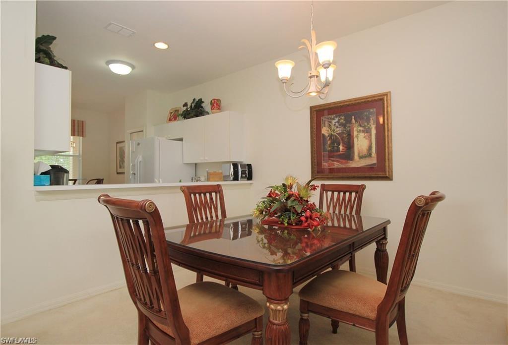 Dining area with a notable chandelier and light carpet
