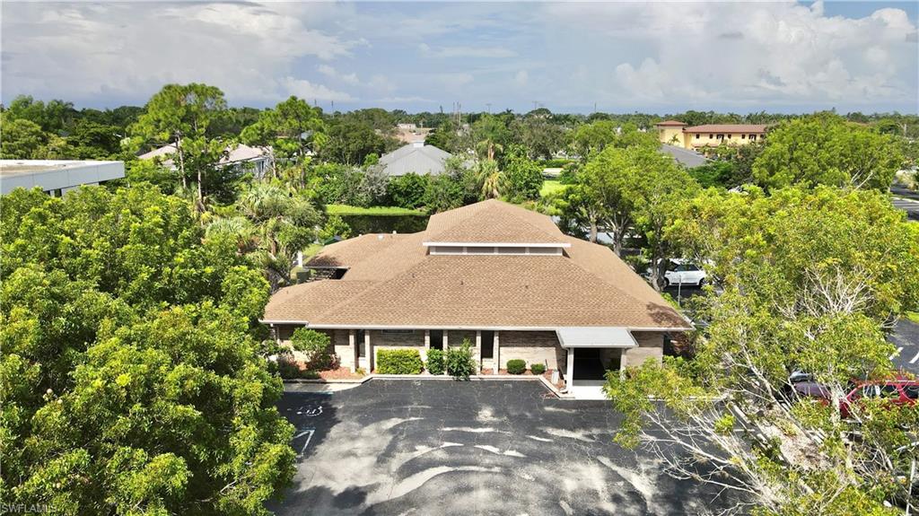Commercial building featuring a shingle roof and a paved parking lot