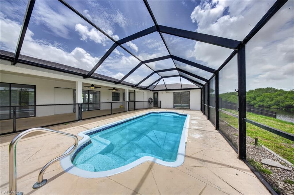 Screened swimming pool with a curved design, integrated steps, and a handrail