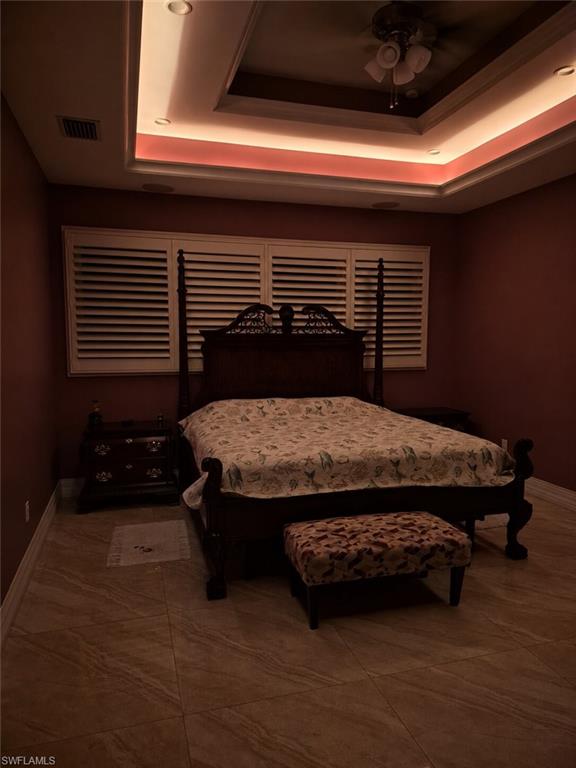 Recessed lighting and cove lighting illuminating a tray ceiling with a ceiling fan