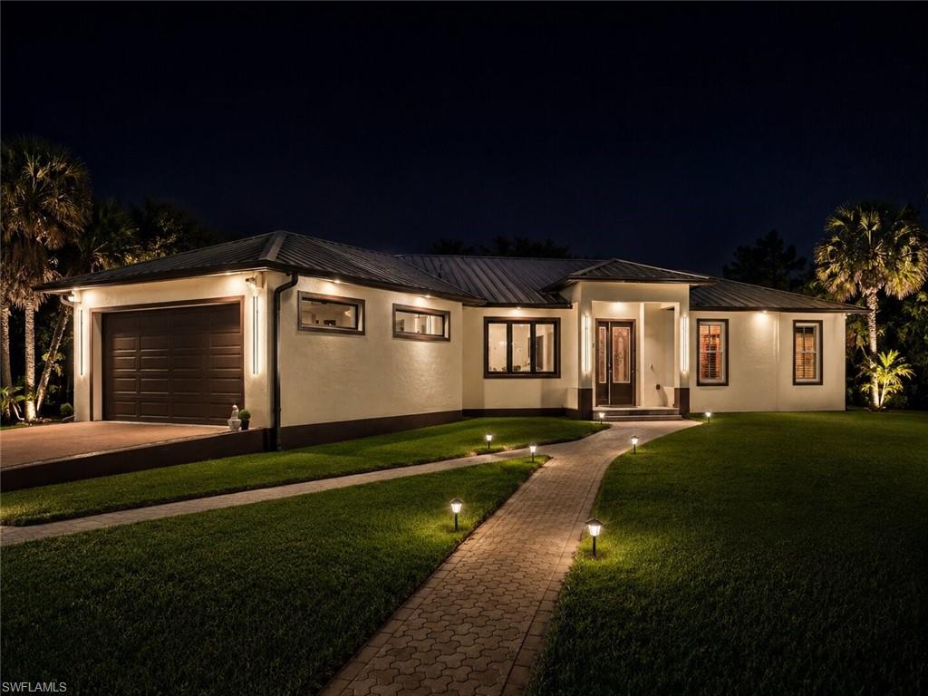 Contemporary exterior featuring a textured stucco finish and a dark metal roof