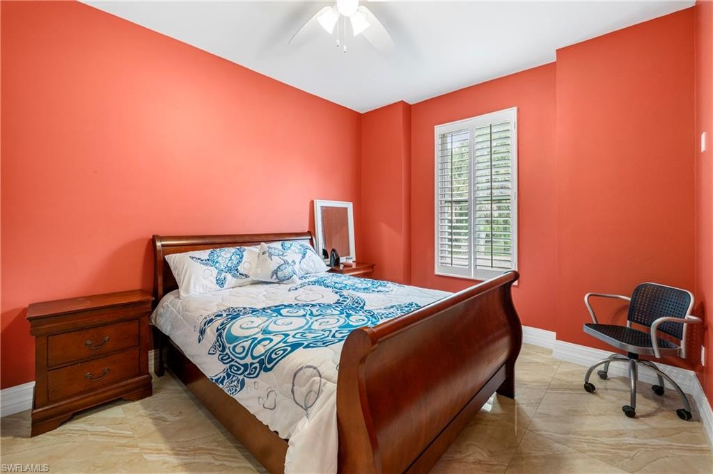 Room featuring a window with white louvered shutters, a ceiling fan, and light-toned tile flooring