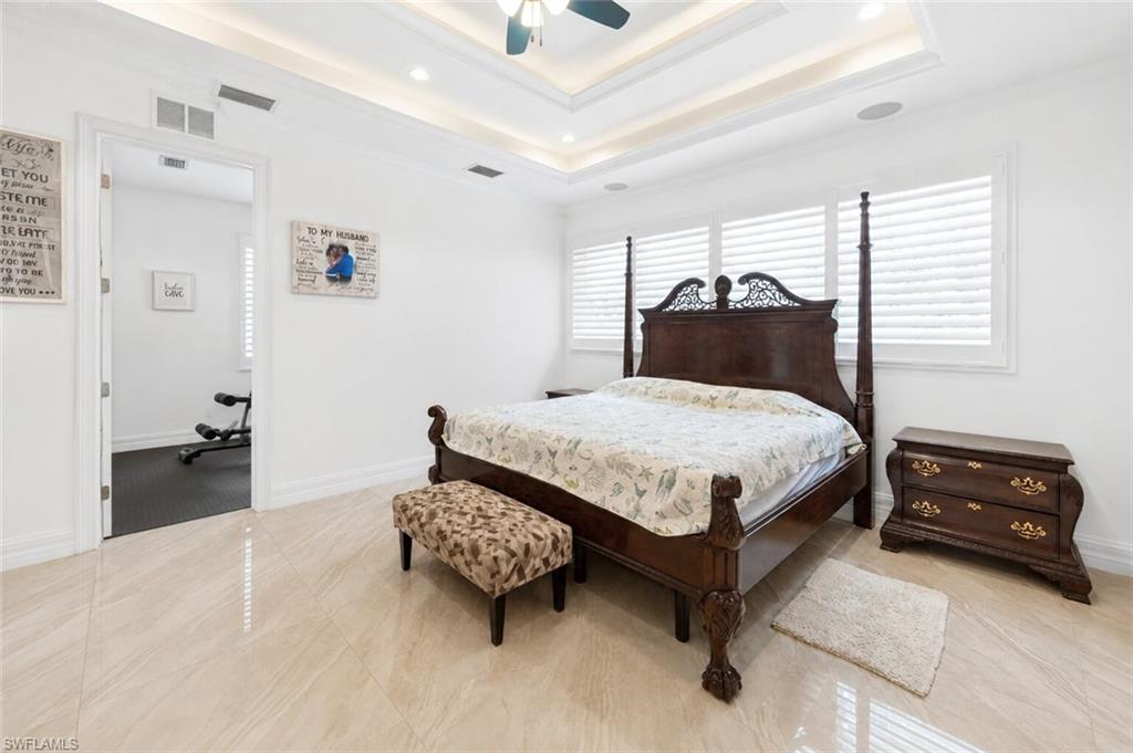 Room featuring light-toned large format tile flooring and a tray ceiling with recessed lighting