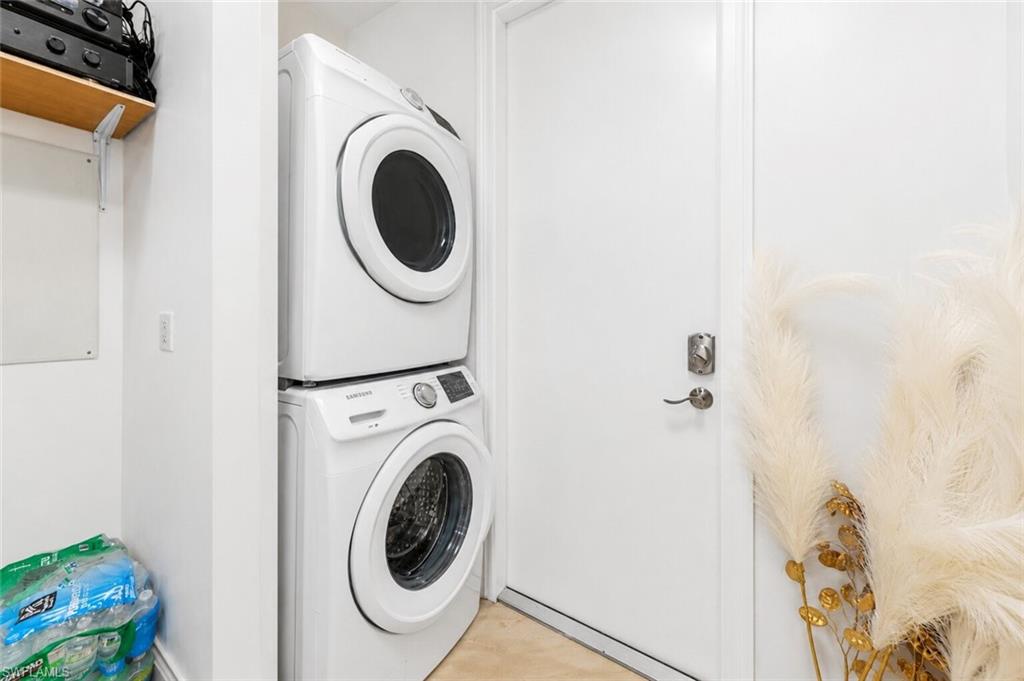 Dedicated laundry area featuring a stacked washer and dryer unit