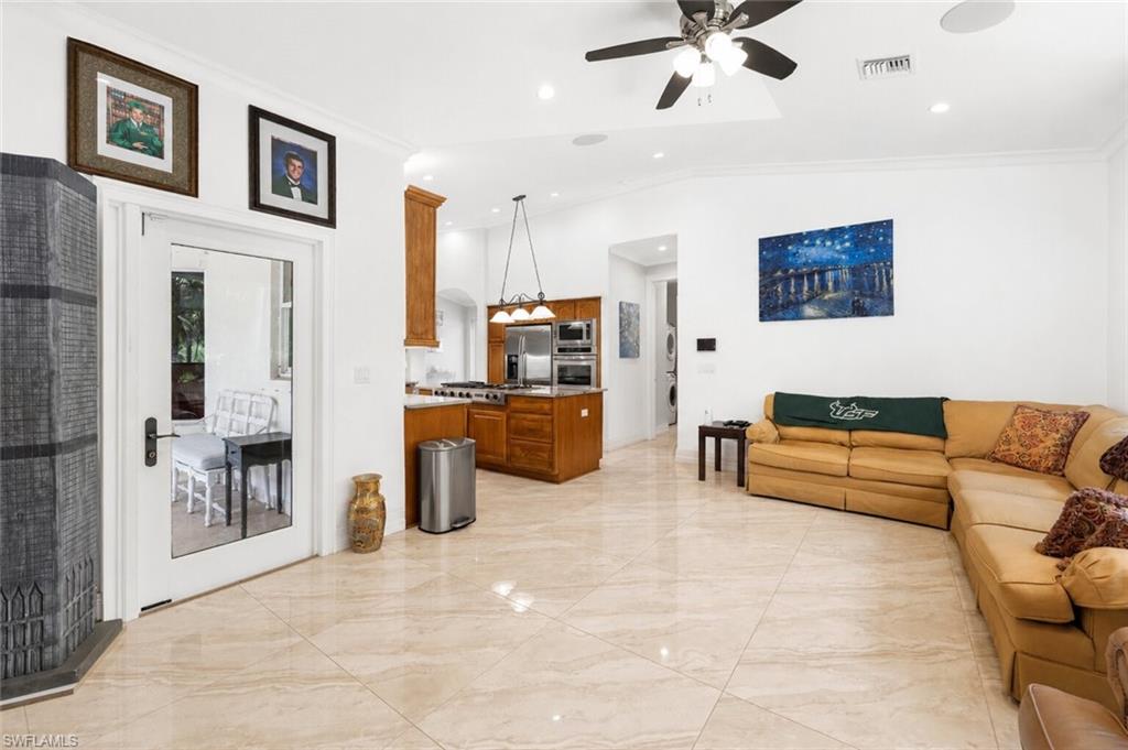 Open-concept living space featuring light-toned tile flooring, recessed lighting, and a ceiling fan