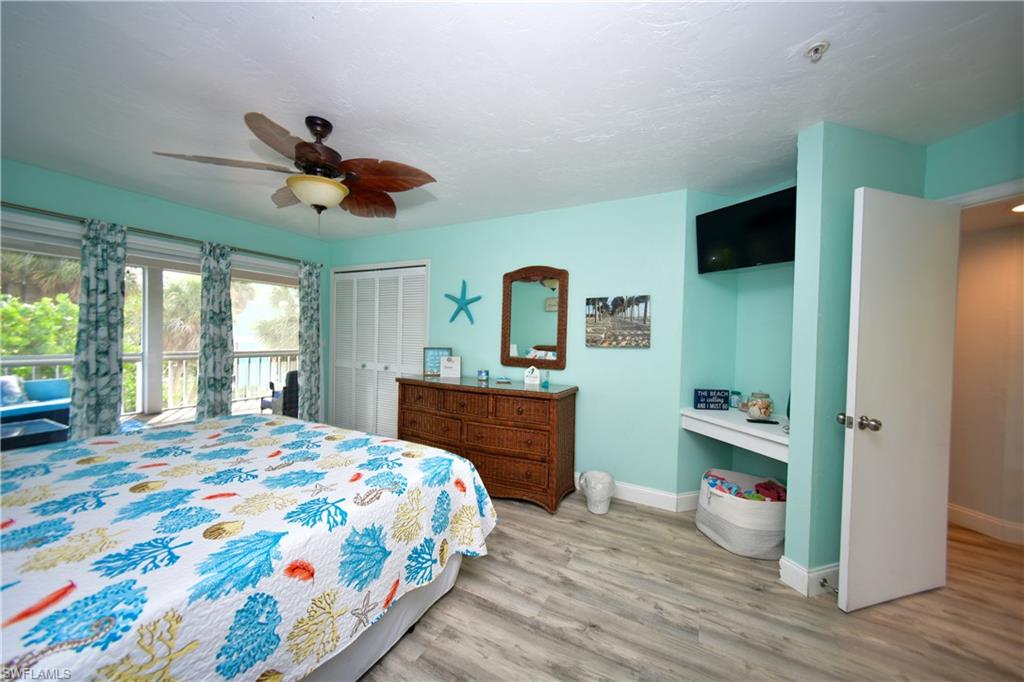 Spacious interior featuring wood-finish flooring and a ceiling fan with palm-leaf blades