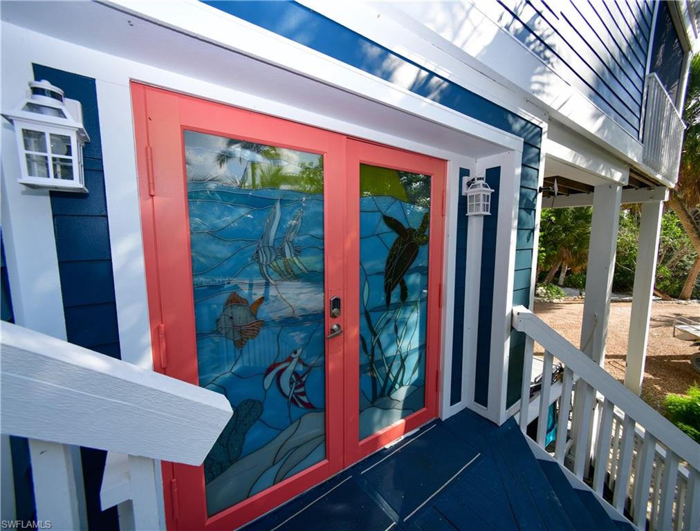 Double entry doors with coral-tone frames and marine-themed stained glass panels
