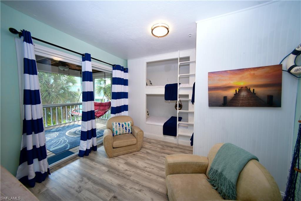 Interior space featuring built-in bunk beds with ladders, wood-finish flooring, and a sliding glass door opening to a screened balcony