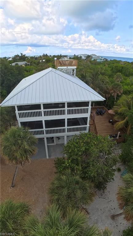 Outdoor living is a highlight of the property, with decks on every level, including two spacious screened porches with overhead fans that provide the perfect setting for outdoor dining, entertaining, or relaxing while enjoying the island breeze.