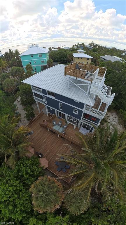 Elevated coastal residence featuring a metal roof and multiple levels of outdoor decking