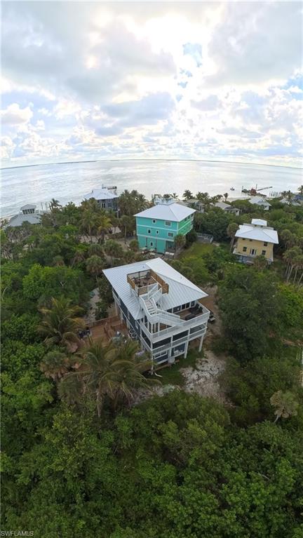 Elevated coastal residence featuring multiple balconies, a rooftop deck, and a metal roof