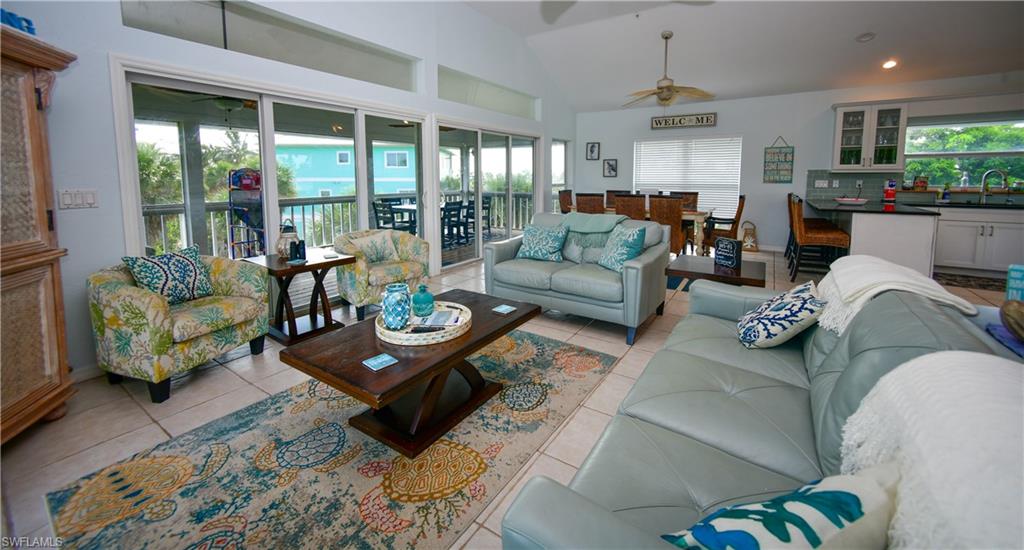 Spacious open-concept living area featuring a vaulted ceiling and tile flooring