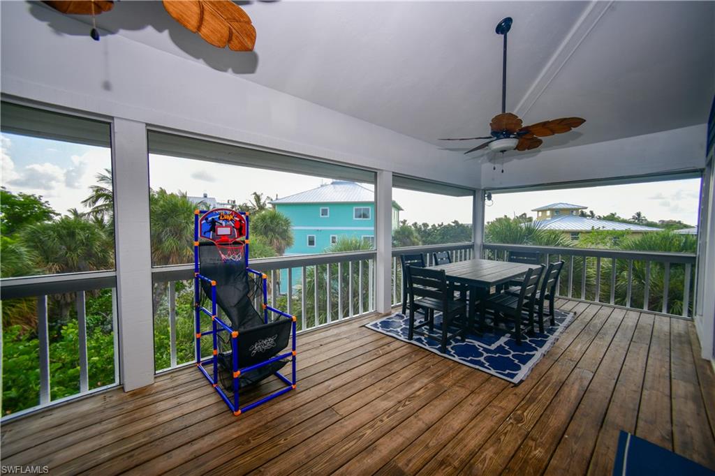 Screened porch featuring wood-finish flooring and a wood-blade ceiling fan