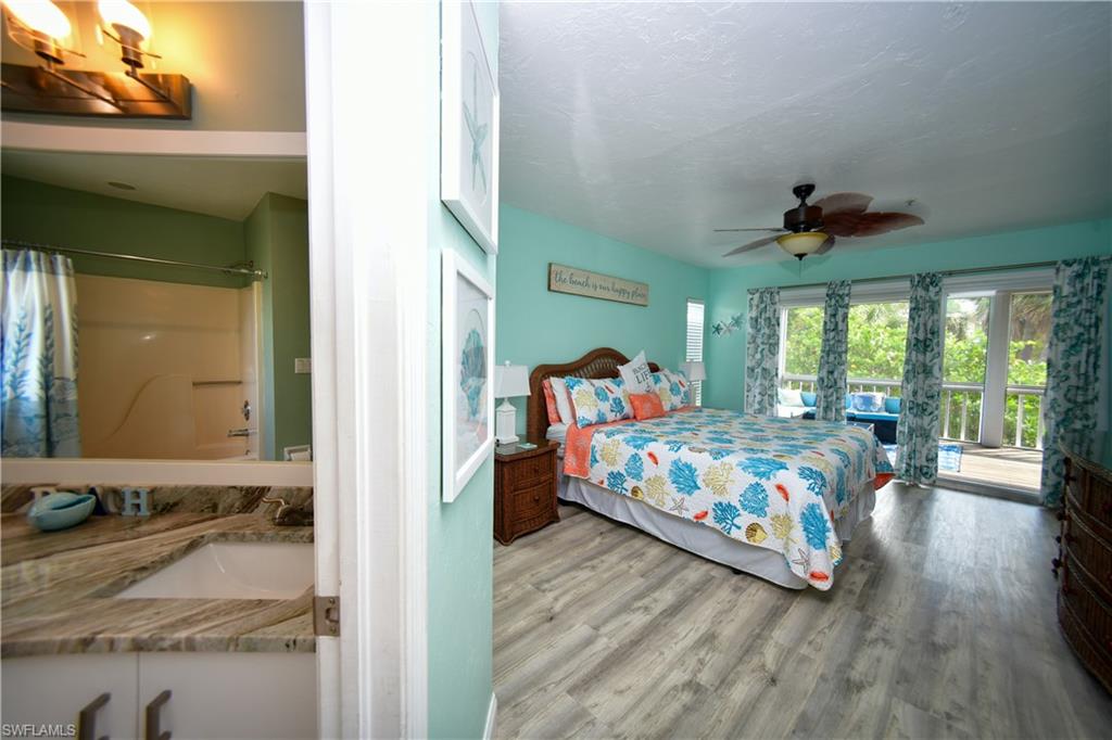 Room featuring wood-finish flooring, a ceiling fan, and access to an outdoor balcony
