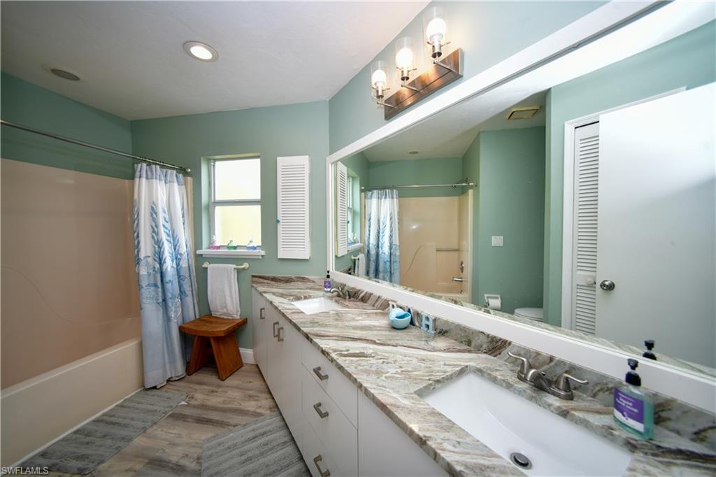 Bathroom featuring an extended double vanity with integrated sinks and stone-finish countertops
