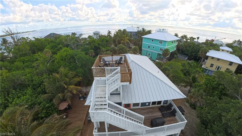 Coastal property featuring multiple outdoor deck spaces, a rooftop deck with seating, and a metal roof