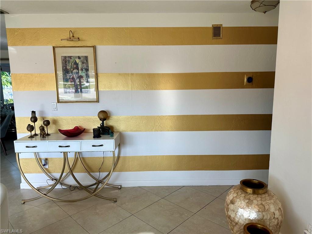 Entry featuring gold-stripe accent wall