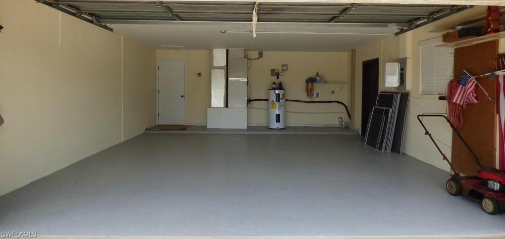 Spacious two-car garage with a light gray epoxy-coated floor, painted walls, insulated roof and recessed lighting