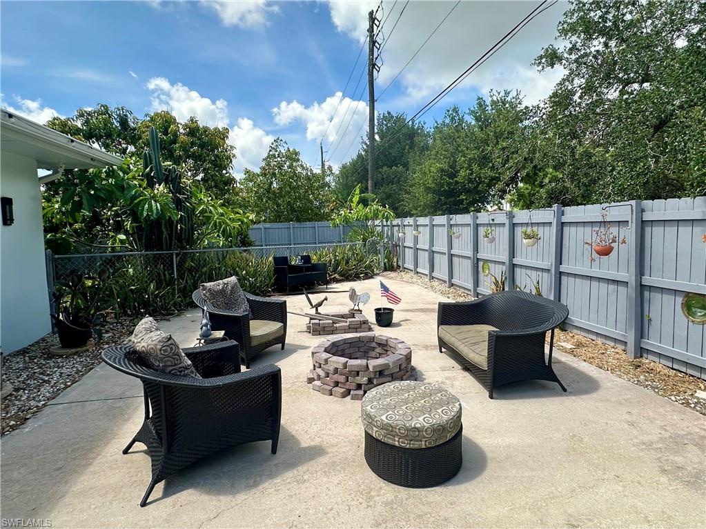 Paved backyard patio with a privacy fence and mature perimeter trees